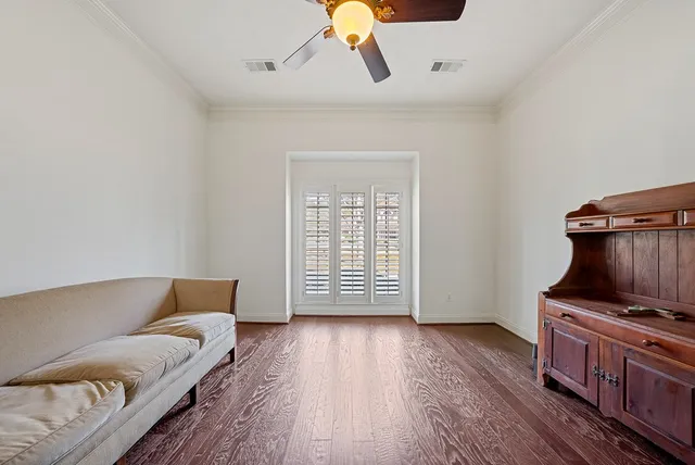 an empty room with wooden floor fireplace and windows