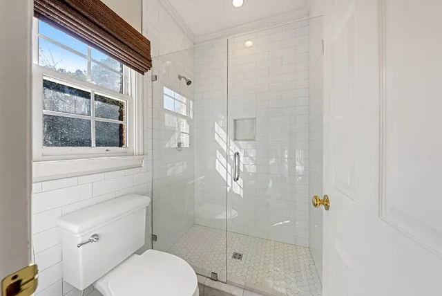 a bathroom with a granite countertop sink mirror vanity and toilet