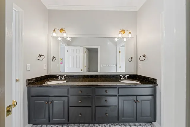 a view of an empty room with chandelier fan and wooden floor