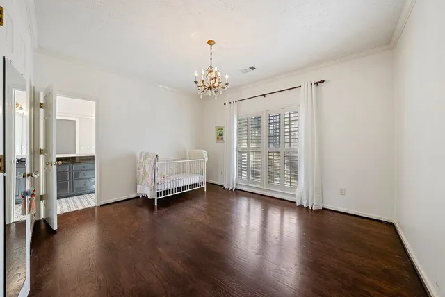 an empty room with wooden floor chandelier fan and windows