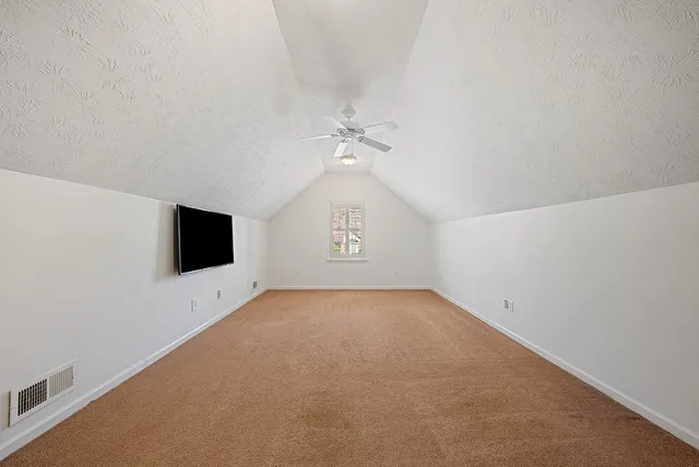 an aerial view of a house with a yard and wooden deck