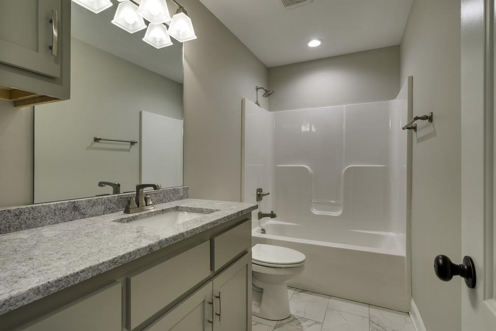 2140 Allisona Road Eagleville, TN 37060 - Photo 28 of 30 a bathroom with a granite countertop sink a toilet and shower