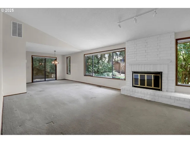 a view of a big room with windows and chandelier