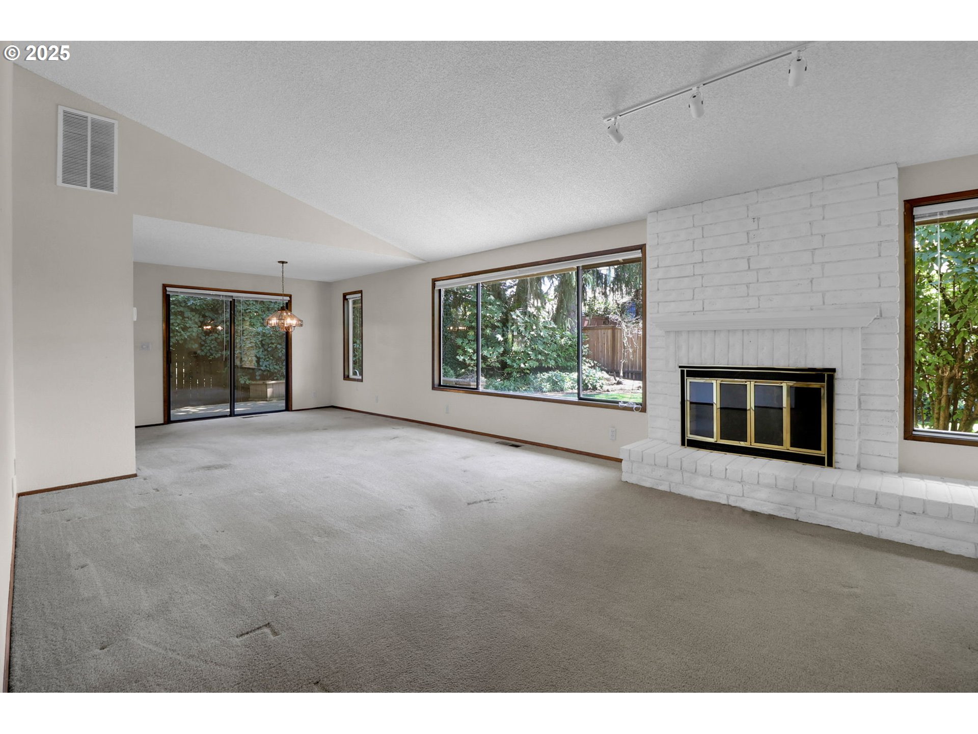 1254 Rio Glen Drive Eugene, OR 97401 - Photo 7 of 43 a view of an empty room with a fireplace and a window