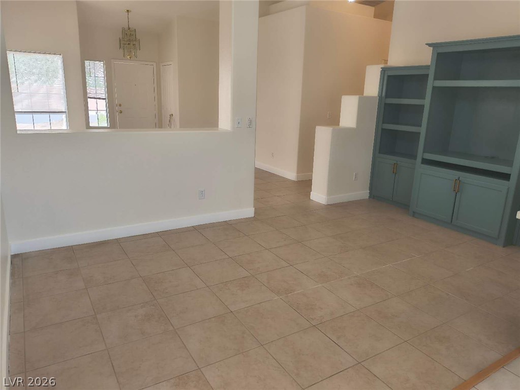 9725 Pima Point Avenue Las Vegas, NV 89147 - Photo 11 of 35 Step into a generously sized living area featuring neutral-toned tile flooring and ample space.