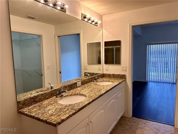a bathroom with a granite countertop sink and a mirror