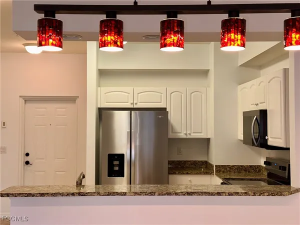 a kitchen with stainless steel appliances granite countertop a refrigerator and a stove top oven