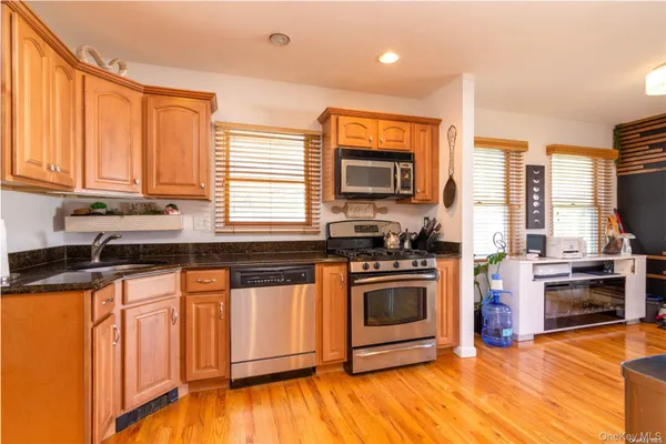 a kitchen with stainless steel appliances granite countertop a stove a sink and a microwave