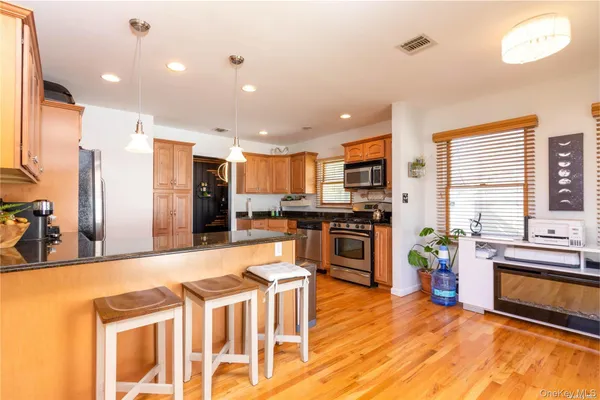 a kitchen with stainless steel appliances kitchen island granite countertop a refrigerator and stove top oven