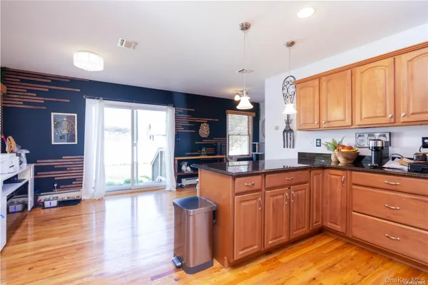 a kitchen with stainless steel appliances granite countertop a stove a sink and a refrigerator with wooden floors