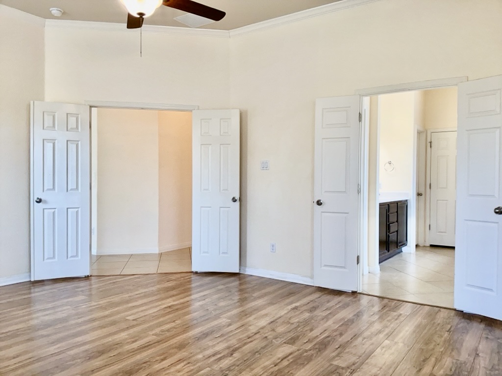 2946 Todd Trail Round Rock, TX 78665 - Photo 15 of 31 Primary bedroom with crown molding, light wood-style floors, and a ceiling fan
