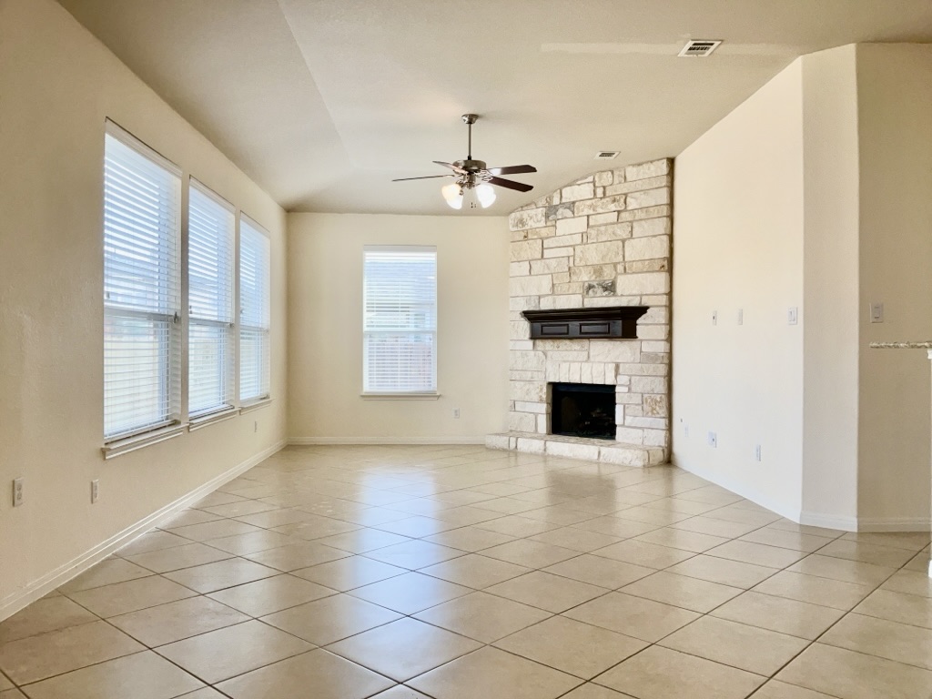 2946 Todd Trail Round Rock, TX 78665 - Photo 3 of 31 Living room featuring a fireplace, lofted ceiling, ceiling fan, and light tile patterned flooring