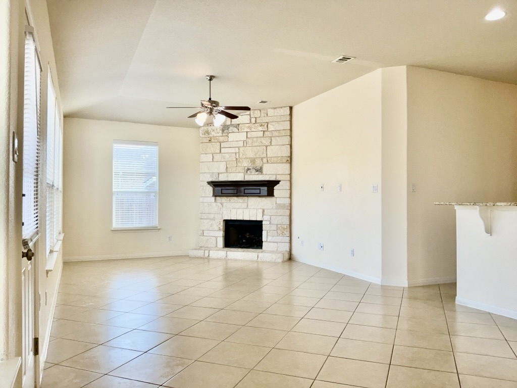 2946 Todd Trail Round Rock, TX 78665 - Photo 4 of 31 Living room with a fireplace, a ceiling fan, and light tile patterned floors