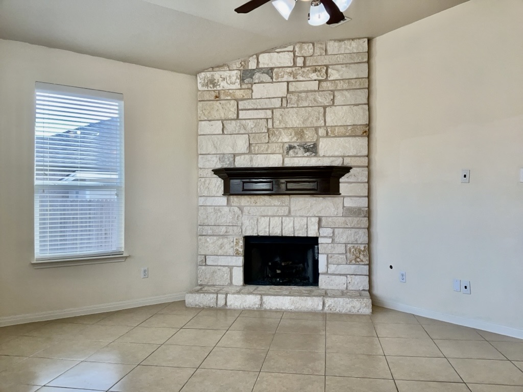 2946 Todd Trail Round Rock, TX 78665 - Photo 5 of 31 Detailed view of a stone fireplace and a ceiling fan