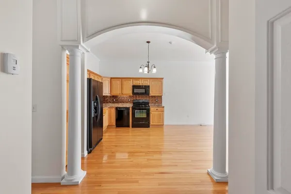 a kitchen with stainless steel appliances granite countertop a refrigerator a stove a sink and a wooden floors