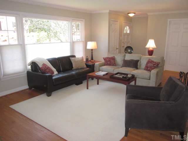 2031 Reaves Drive Raleigh, NC 27608 - Photo 23 of 25 Living room features crown molding, real masonry fireplace with hearth and hardwood floors! Open floor plan between living room and dining room!