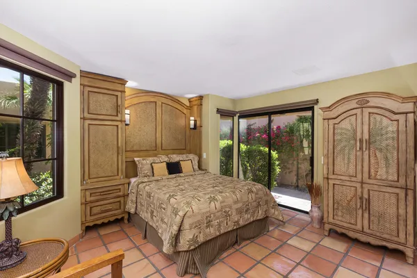 a bedroom with a bed a dresser next to a window