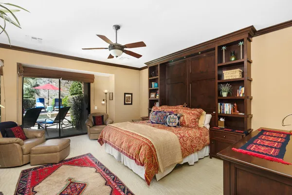 a bedroom with a bed a couch and a chandelier