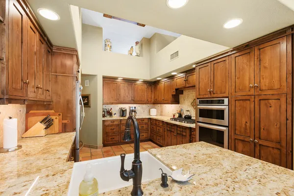 a kitchen with stainless steel appliances kitchen island granite countertop a refrigerator and microwave