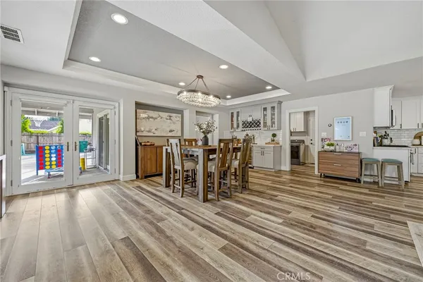 a view of a dining room with furniture a rug and chandelier
