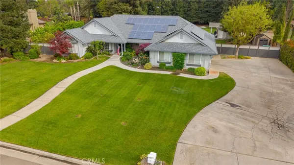 a aerial view of a house with a yard table and chairs