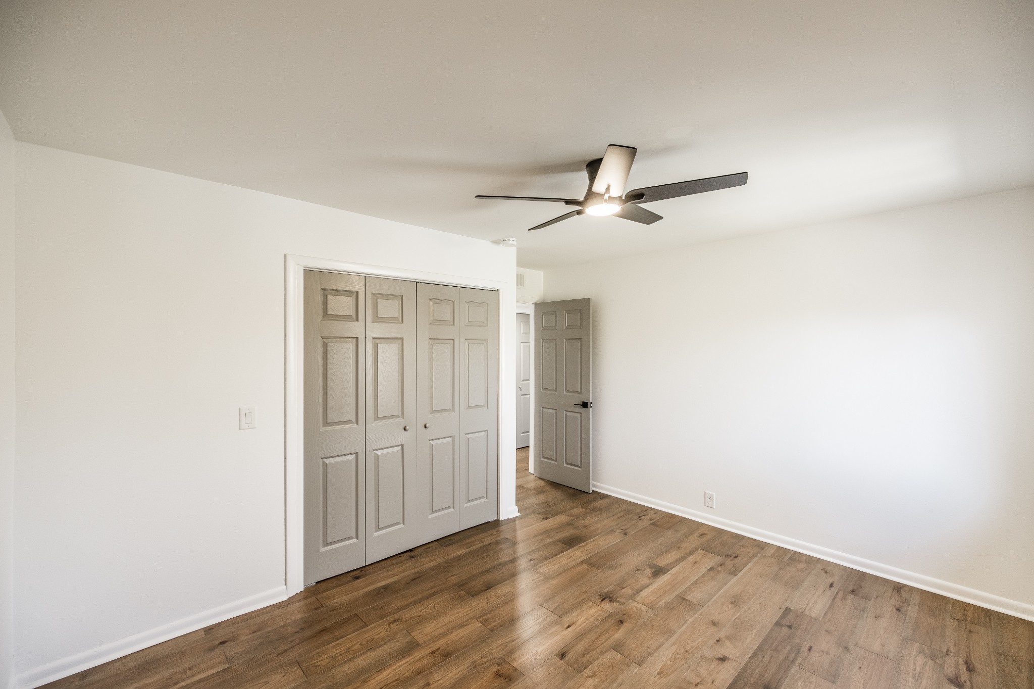 21 Vaughns Gap Road, Unit 55 Nashville, TN 37205 - Photo 19 of 35 an empty room with wooden floor ceiling fan and windows