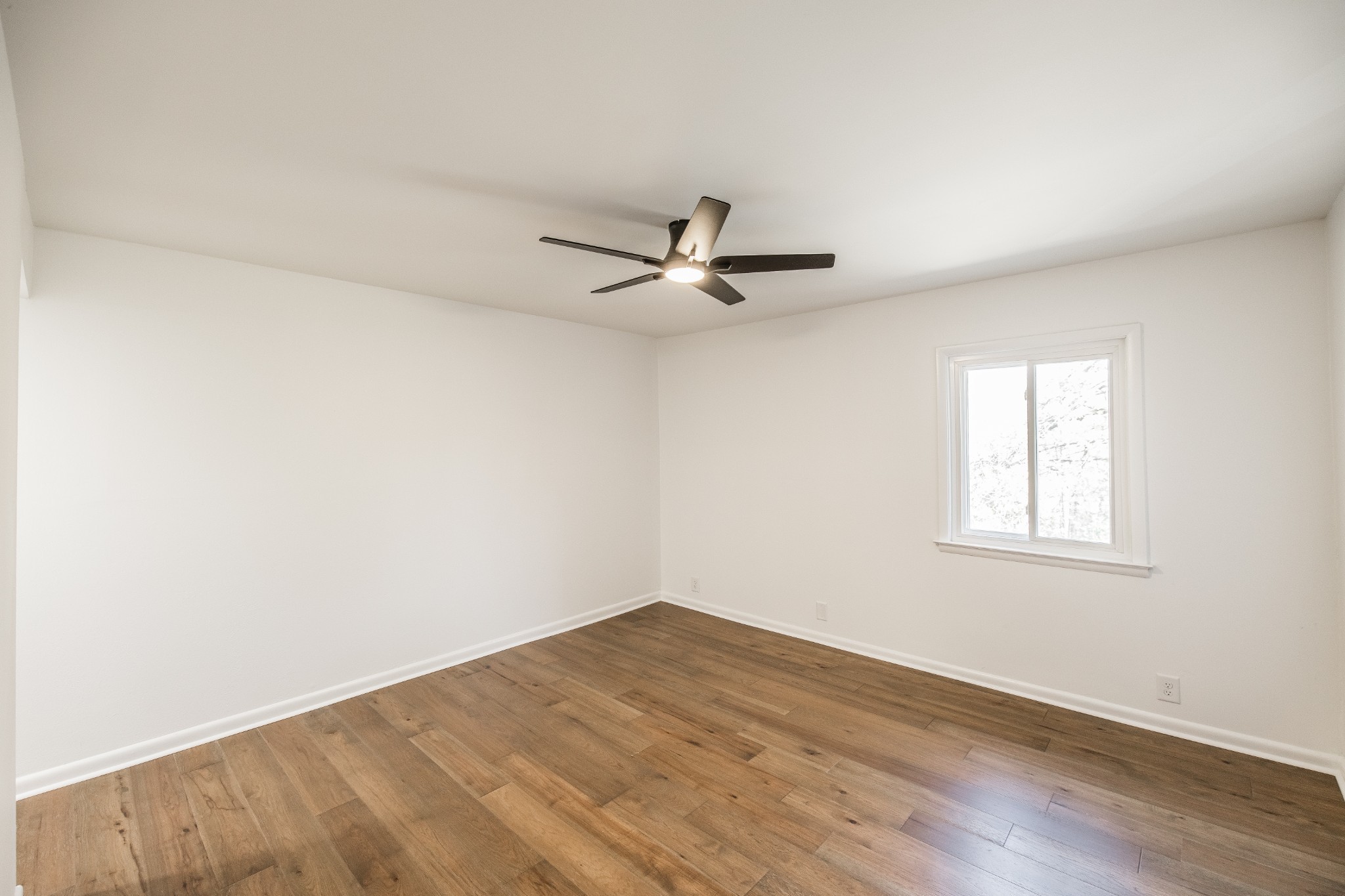 21 Vaughns Gap Road, Unit 55 Nashville, TN 37205 - Photo 20 of 35 an empty room with wooden floor ceiling fan and windows
