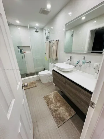 a bathroom with a double vanity sink mirror and toilet