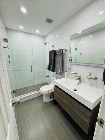 a bathroom with a double vanity sink toilet and shower