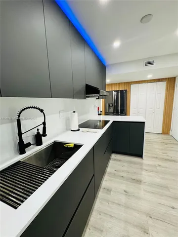 a kitchen with kitchen island stainless steel appliances a sink and cabinets