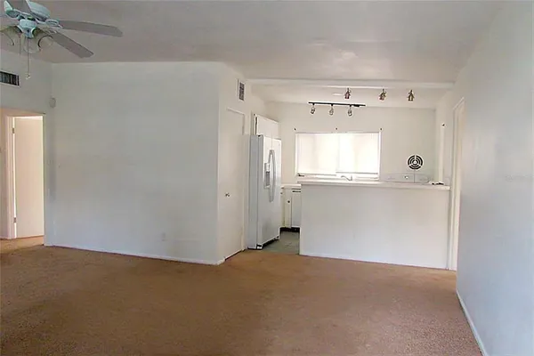 an empty room with a window and a projector screen