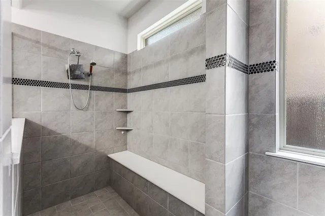 a bathroom with a double vanity sink a mirror and next to a window
