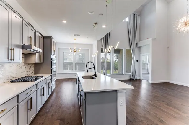 a kitchen with kitchen island stainless steel appliances a stove a sink and a refrigerator