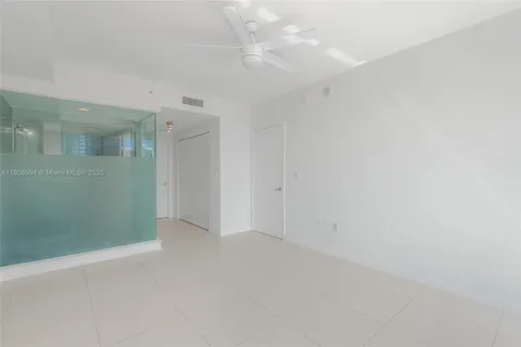 an empty room with fan and entrance