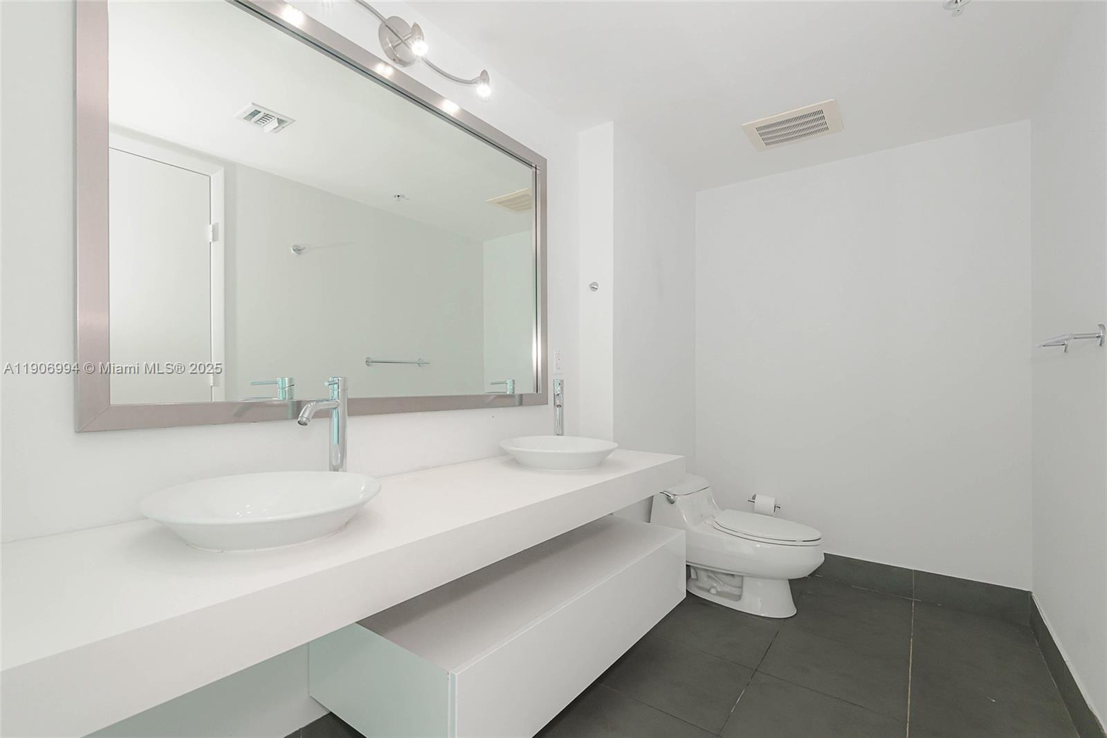 92 Southwest 3rd Street, Unit 3503 Miami, FL 33130 - Photo 24 of 35 a bathroom with a sink and a mirror