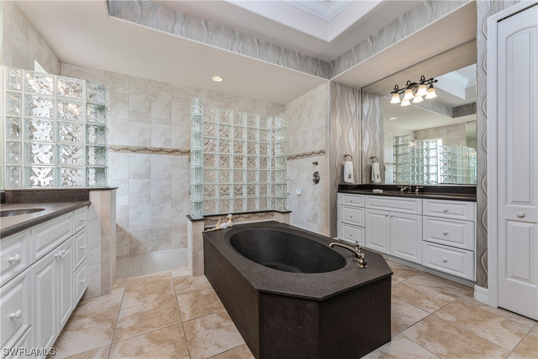 3290 Sugarloaf Key Road Punta Gorda, FL 33955 - Photo 24 of 50 a bathroom with a granite countertop sink a bathtub and a shower