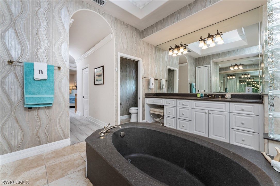 3290 Sugarloaf Key Road Punta Gorda, FL 33955 - Photo 25 of 50 a spacious bathroom with a granite countertop sink a mirror and a bathtub