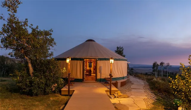 a view of a house with backyard and sitting area