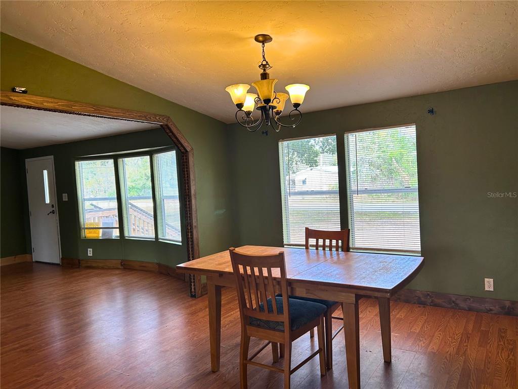 9867 Jerome Drive New Port Richey, FL 34654 - Photo 12 of 30 a view of a dining room with furniture window and wooden floor
