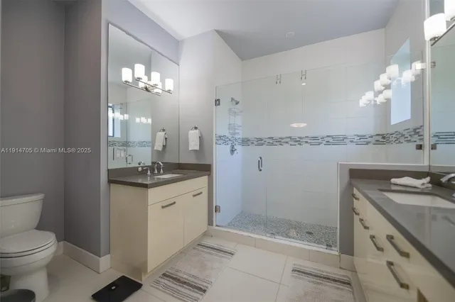 a spacious bathroom with a granite countertop sink a toilet and shower