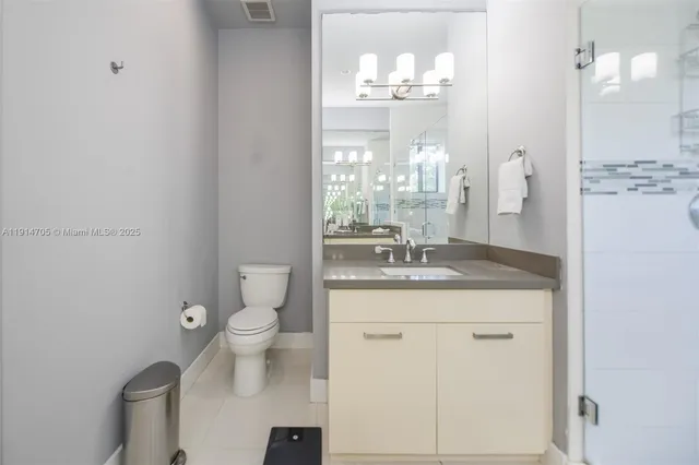 a bathroom with a granite countertop sink a toilet and a mirror
