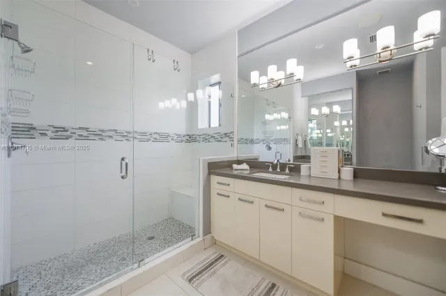 a bathroom with a double vanity sink mirror and shower