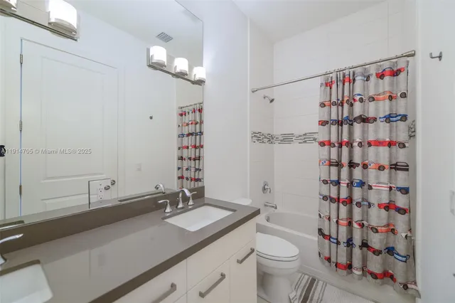 a bathroom with a sink a toilet and shower curtain