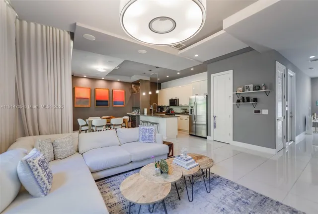 a living room with furniture and a dining table with wooden floor