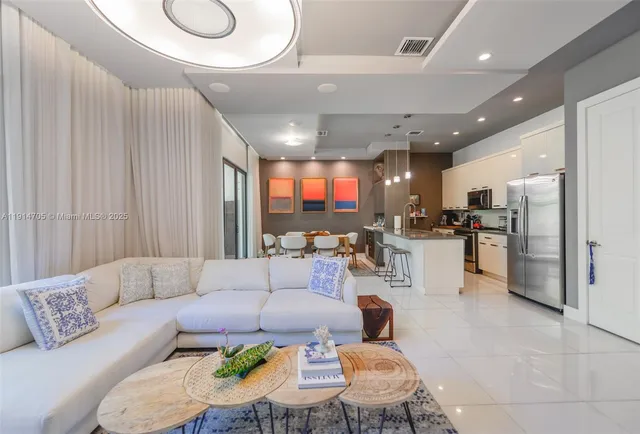 a living room with furniture and kitchen view