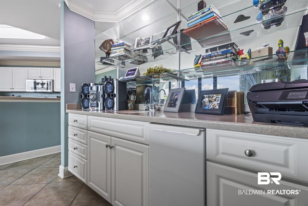 27582 Canal Road, Unit 2408 Orange Beach, AL 36561 - Photo 7 of 47 Bar featuring white cabinets, fridge, ornamental molding, and tile patterned floors