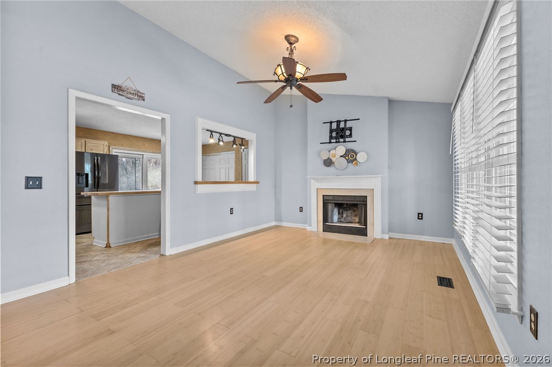 237 Lemuel Black Road Bunnlevel, NC 28323 - Photo 13 of 37 a view of a livingroom with a fireplace a ceiling fan and windows