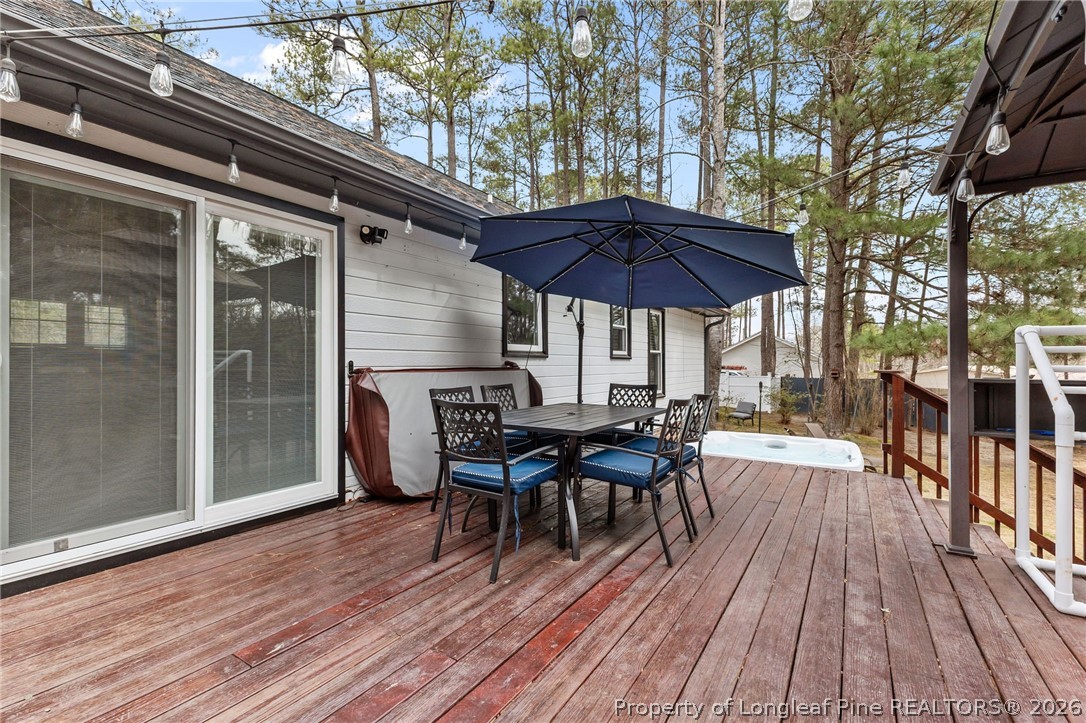 237 Lemuel Black Road Bunnlevel, NC 28323 - Photo 32 of 37 a view of a roof deck with table and chairs under an umbrella with wooden floor
