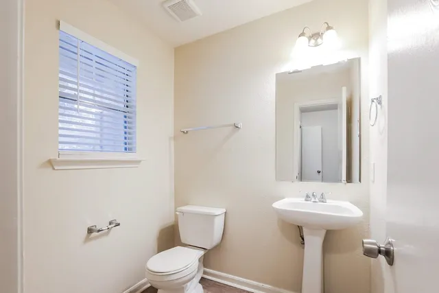 a bathroom with a toilet sink and mirror
