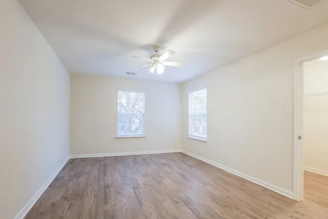 an empty room with wooden floor and window
